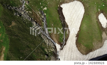 Aerial view of a rocky stream cutting through mountain terrain and forest . Media Aerial view of a rocky stream cutting through mountain terrain and forest . Media 142889928