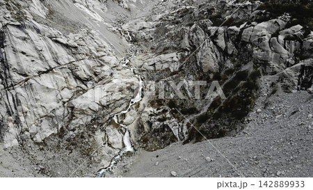 Rocky mountain ravine with small waterfall 142889933