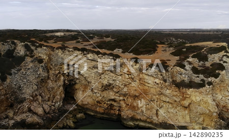 Uneven Coastline Characterized By Vivid Ochre And Exposed Limestone Surfaces With Sparse Vegetation. Media Uneven Coastline Characterized By Vivid Ochre And Exposed Limestone Surfaces With Sparse Vegetation. Media 142890235