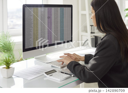 Businesswoman Managing Accounting Online In Office 142890709
