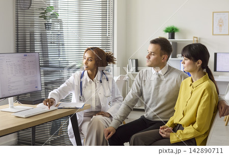 Doctor showing test results to couple during fertility and pregnancy planning Doctor showing test results to couple during fertility and pregnancy planning 142890711