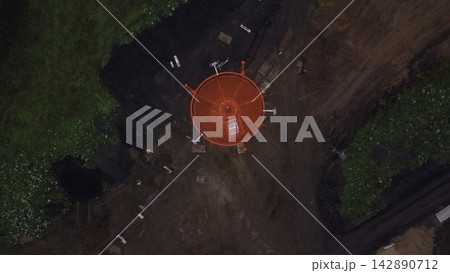 Aerial view of red circular metal structure in forest clearing 142890712
