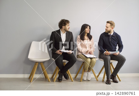 Job interview candidates waiting and chatting in lobby before assessment 142890761