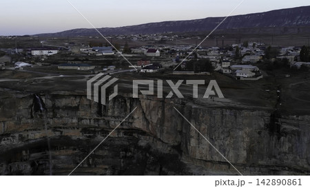Aerial view of a small town beside a vast rocky quarry and cliff. Media Aerial view of a small town beside a vast rocky quarry and cliff. Media 142890861