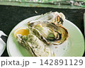 レモンが添えられた皿の上の美味しそうな焼き牡蠣のクローズアップ（海のミルク・グルメ） 142891129