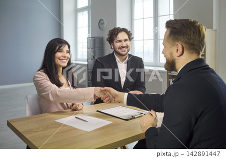Successful job interview handshake as recruiters welcome hired candidate in office Successful job interview handshake as recruiters welcome hired candidate in office 142891447
