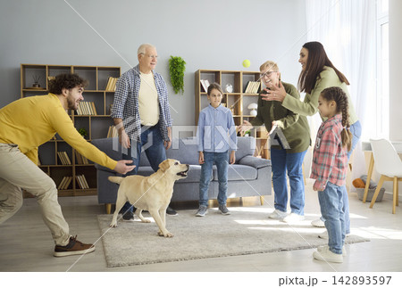 Cheerful parents children and grandparents play with Labrador dog in cozy home Cheerful parents children and grandparents play with Labrador dog in cozy home 142893597
