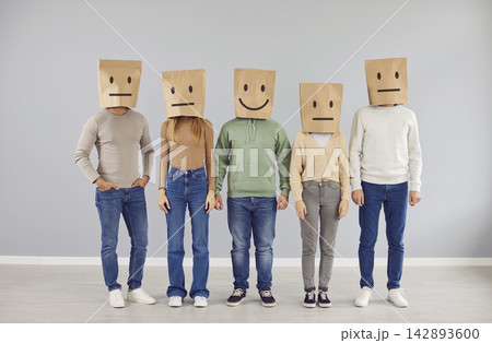 Happy smiling person and group of serious indifferent people with paper bags on heads Happy smiling person and group of serious indifferent people with paper bags on heads 142893600