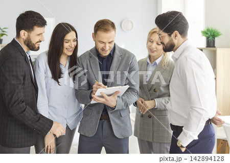 Business people team leader coach mentor talking to diverse business people in office 142894128