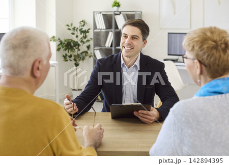 Senior couple consulting with agent about agreement terms during friendly meeting Senior couple consulting with agent about agreement terms during friendly meeting 142894395