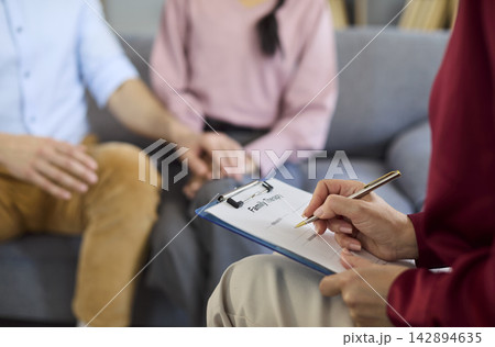 Couple with therapist in counseling session, closeup of notes and support Couple with therapist in counseling session, closeup of notes and support 142894635