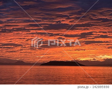 燃えるような朝焼けに島と海が溶けていく 燃えるような朝焼けに島と海が溶けていく 142895930