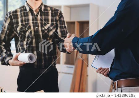 Asian architect and engineer team checking architectural house model using measuring tape on the table at office studio. 142896185
