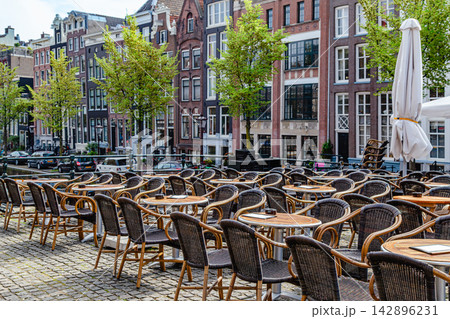 Outdoor dining area along scenic canal in Amsterdam Outdoor dining area along scenic canal in Amsterdam 142896231