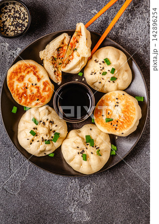 Delicious buns served on a plate with sauces and toppings 142896254