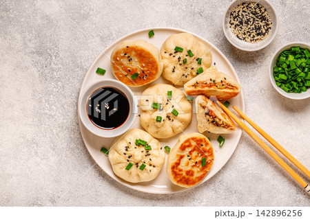 Delicious buns served on a plate with sauces and toppings 142896256