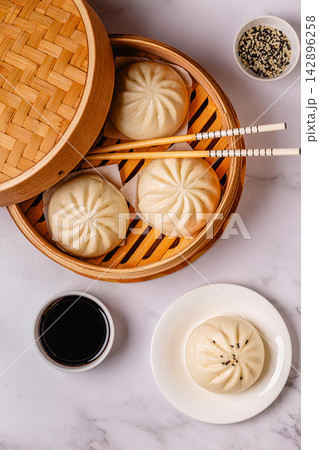 Steamed buns in bamboo steamer on a kitchen counter 142896258