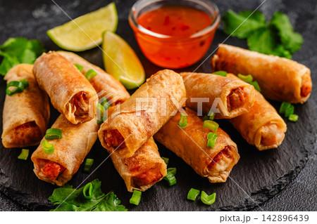 Fried spring rolls served with sauce and lime 142896439