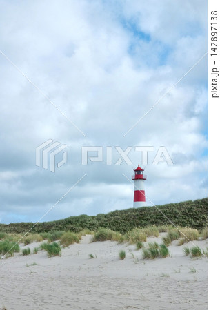 Scenic Coastal Landscape with Iconic Red and White Lighthouse in Tranquil Setting Scenic Coastal Landscape with Iconic Red and White Lighthouse in Tranquil Setting 142897138