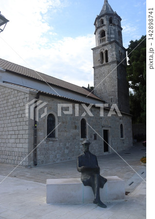 Bronze statue of painter Vlaho Bukovac and Church of Our Lady of the Snows in Cavtat, Croatia Bronze statue of painter Vlaho Bukovac and Church of Our Lady of the Snows in Cavtat, Croatia 142898741