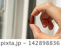 Brown gel pills, dark red capsules close up 142898836