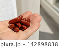 Brown gel pills, dark red capsules close up 142898838