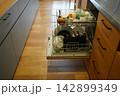 開いた食洗機と木目の床のあるキッチン 142899349