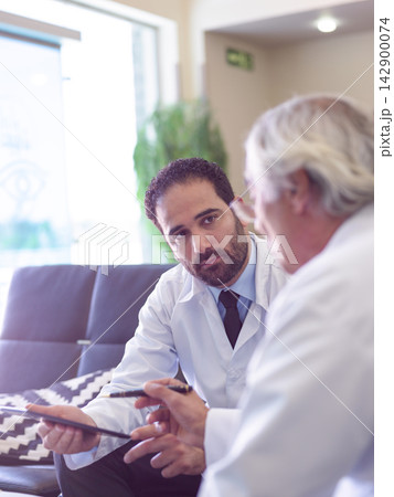 Middle Eastern doctors in clinic discussing patient care during a focused medical consultation Middle Eastern doctors in clinic discussing patient care during a focused medical consultation 142900074