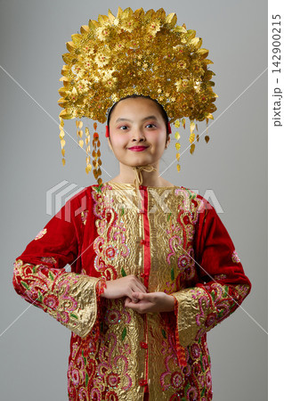 Traditional Headdress And Ornate Red Gold Costume Portrait Of A Young Indonesian Asian Girl For Festival Or Ceremony Traditional Headdress And Ornate Red Gold Costume Portrait Of A Young Indonesian Asian Girl For Festival Or Ceremony 142900215