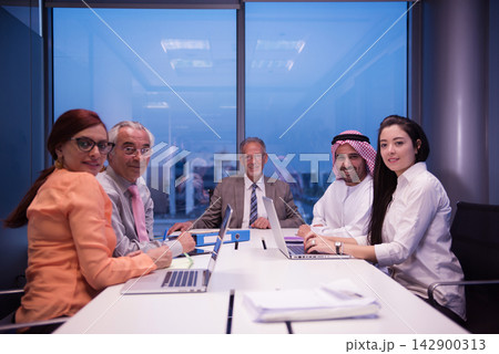 Diverse Middle Eastern and international business team in a modern office meeting around a conference table Diverse Middle Eastern and international business team in a modern office meeting around a conference table 142900313