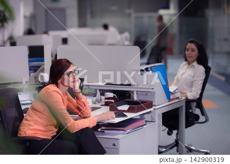 Middle Eastern businesswomen collaborating in a modern open office during a relaxed work meeting and planning session Middle Eastern businesswomen collaborating in a modern open office during a relaxed work meeting and planning session 142900319
