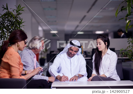 Middle Eastern business people signing contract in modern open-space office during friendly meeting 142900527