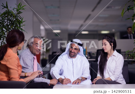 Middle Eastern business team meeting in modern open office with Arab professionals collaborating 142900531