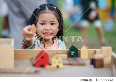 preschool child girl playing with wooden toy block at outdoor 142900558