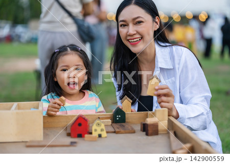 mother and preschool child girl playing with wooden toy block at outdoor mother and preschool child girl playing with wooden toy block at outdoor 142900559