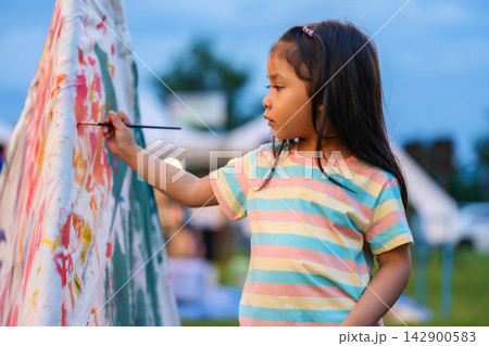 preschool child girl painting watercolors on canvas outdoors in park preschool child girl painting watercolors on canvas outdoors in park 142900583