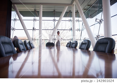 Middle Eastern businesswoman standing confidently at the end of a modern corporate boardroom table in a startup office 142901024