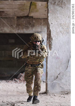 Armed Soldier In Camouflage Tactical Gear Moving Through Abandoned Urban Building On Mission 142901361