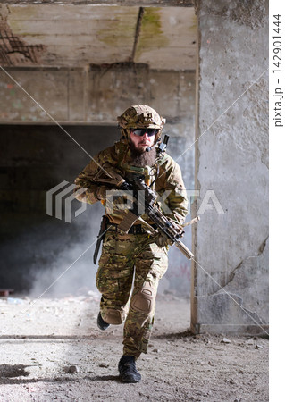 Soldier in Tactical Gear Running With Rifle Inside Abandoned Building During Urban Combat Training 142901444