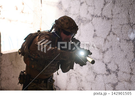 Tactical Soldier With Rifle and Flashlight Conducting Urban Close Quarters Battle Training Indoors Tactical Soldier With Rifle and Flashlight Conducting Urban Close Quarters Battle Training Indoors 142901505