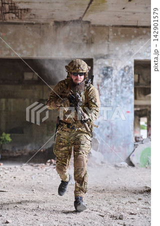 Armed Soldier Running Through Abandoned Building In Tactical Gear During Urban Combat Training Exercise 142901579