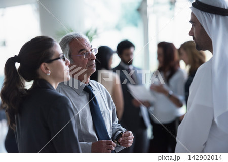 Business professionals networking and discussing strategy in a diverse corporate meeting space Business professionals networking and discussing strategy in a diverse corporate meeting space 142902014