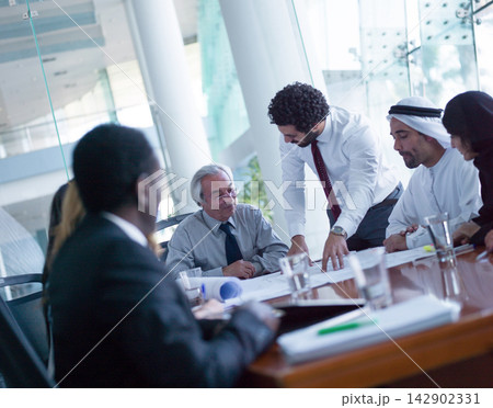 Multicultural Middle Eastern corporate team collaborating in a modern office business meeting around a conference table Multicultural Middle Eastern corporate team collaborating in a modern office business meeting around a conference table 142902331