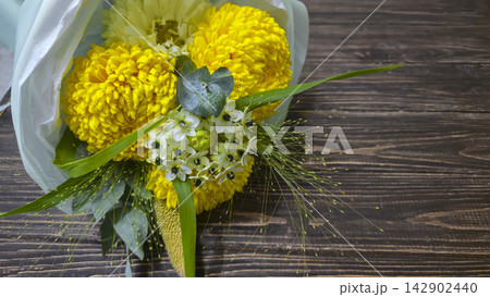 A bouquet of chrysanthemums and other flowers in light-colored wrapping paper A bouquet of chrysanthemums and other flowers in light-colored wrapping paper 142902440