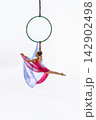 Teen gymnast posing below green aerial ring 142902498