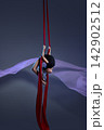 Teen girl folding into aerial silk pose 142902512