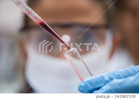 Middle Eastern medical technician and young doctor performing blood testing in laboratory with pipette and test tube Middle Eastern medical technician and young doctor performing blood testing in laboratory with pipette and test tube 142902539
