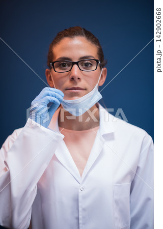 Female doctor and lab technician wearing mask and gloves preparing for blood testing in laboratory Female doctor and lab technician wearing mask and gloves preparing for blood testing in laboratory 142902668