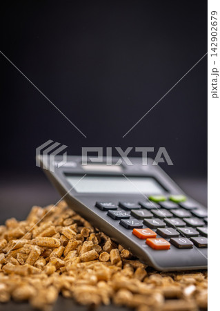 Calculator on Wood Pellets Representing Biomass Fuel Cost, Energy Calculation and Heating Budget Concept Calculator on Wood Pellets Representing Biomass Fuel Cost, Energy Calculation and Heating Budget Concept 142902679