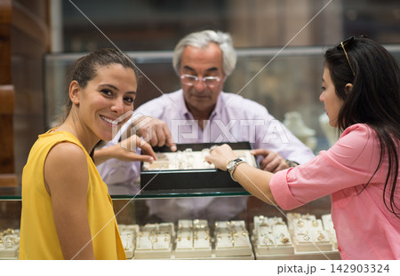 Middle Eastern couple shopping for a wedding ring with friends and family at a jewelry store Middle Eastern couple shopping for a wedding ring with friends and family at a jewelry store 142903324